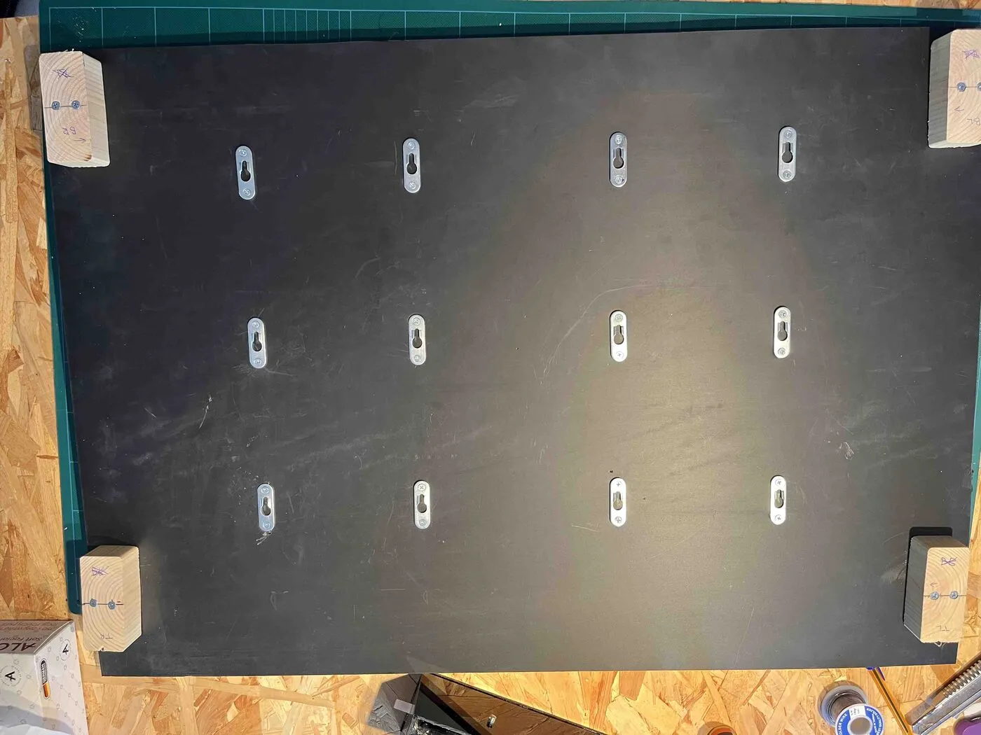 The front of the black PVC back panel with twelve keyhole slots in three rows.