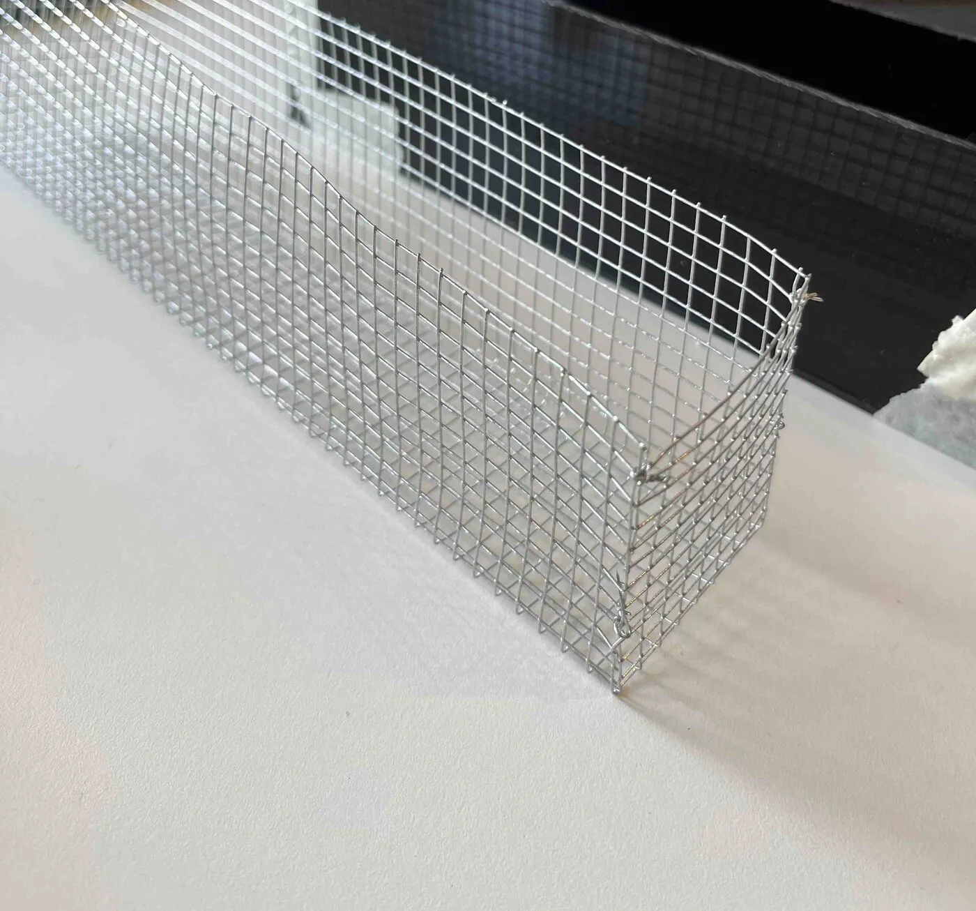 A finished wire-mesh cup beside a black acrylic planter.